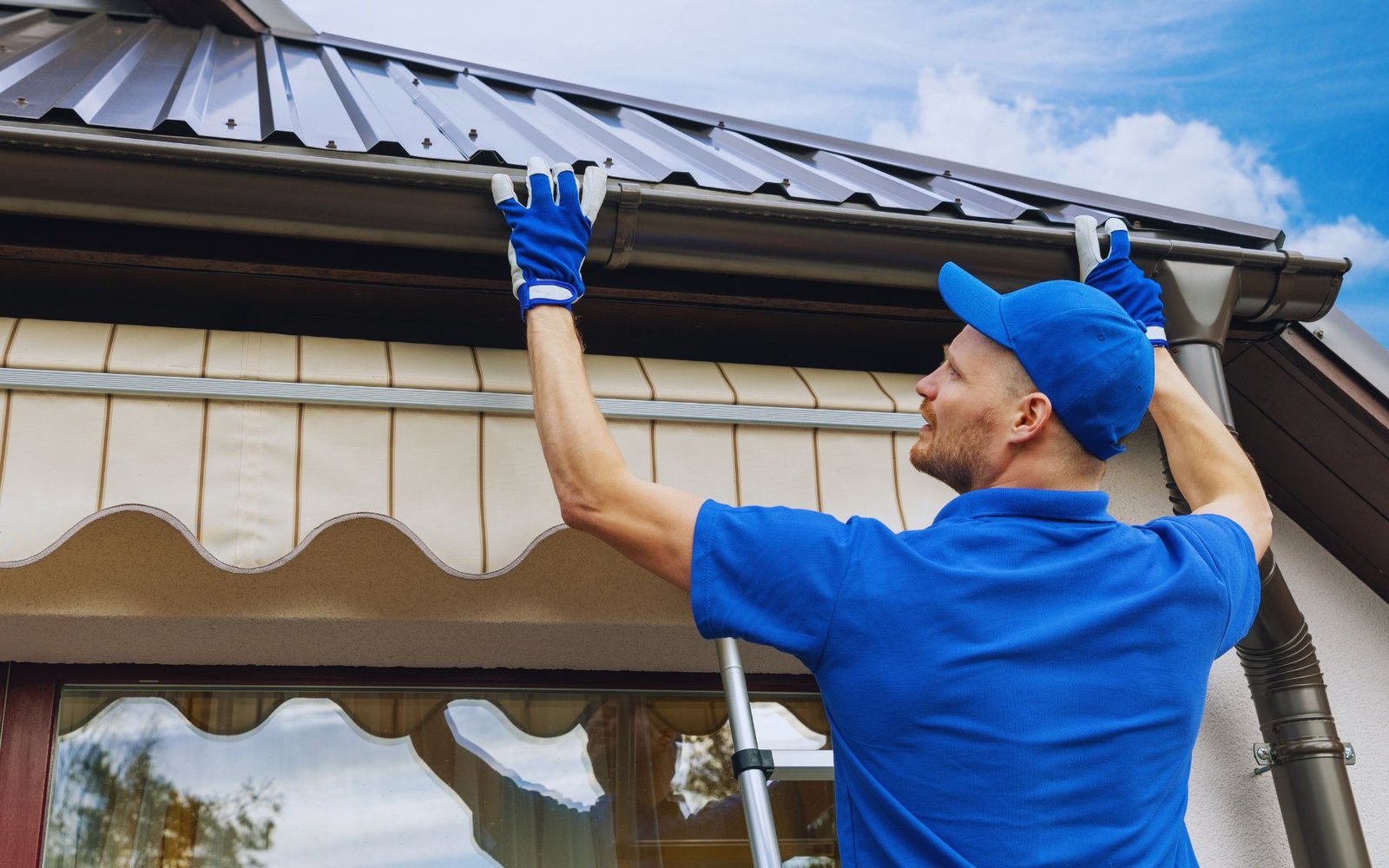 Man performing gutter repair work using safety equipment
